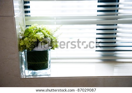 A bouquet of flowers standing on the window sill windows closed shutters.