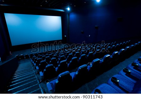 Dark movie theatre interior. screen, chairs