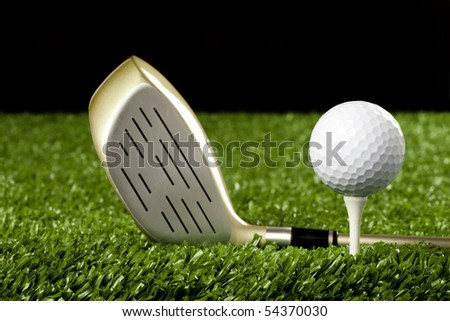Golf club(driver) on grass with golf ball on tee , dark background
