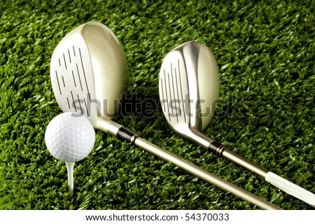 Golf clubs(driver) on grass with golf ball on tee close up