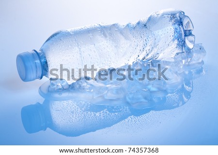water bottle lying on its side on ice with droplets on it, shot in cool blue tone
