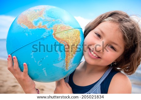 I love my world! Young girl hugs Earth globe