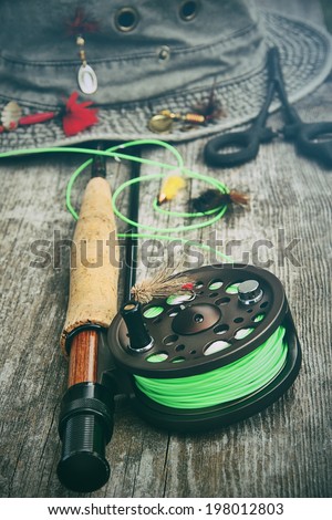 Fly-fishing reel with old hat and equipment on bench