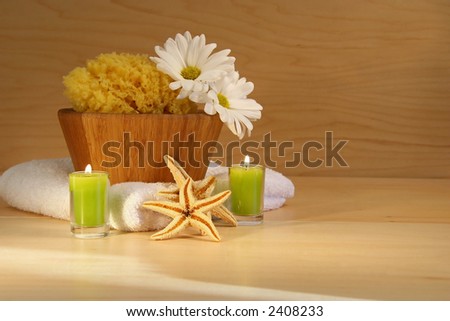 Wooden bowl, sponge, towel and candles on wooden counter