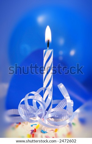 Small blue candle with ribbons ready for a birthday