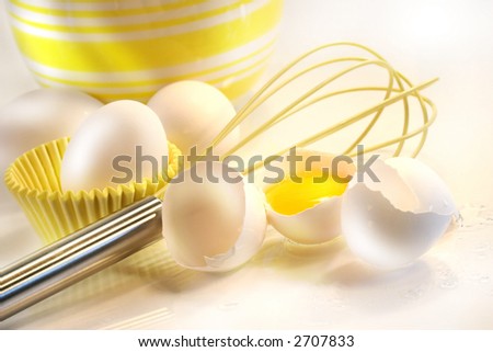 Yellow egg yolk with eggs and whisk for baking