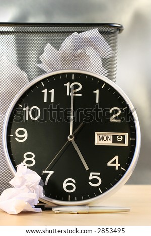 Clock showing time with waste paper basket in background