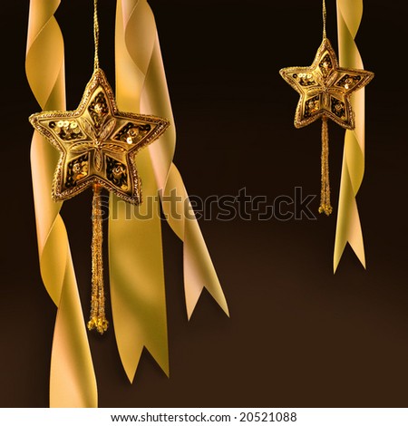 Gold christmas star with ribbons against dark background