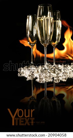 Glasses of champagne with ice and fire on black