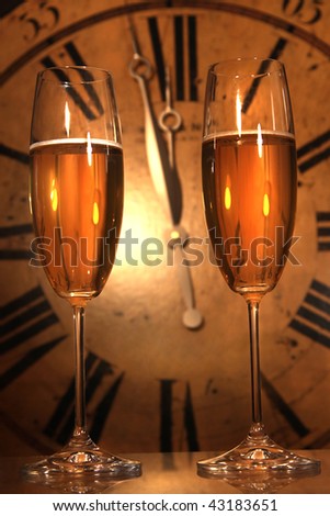 Champagne glasses ready to bring in the New Year with clock