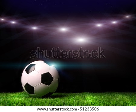 Soccer ball on grass against black background