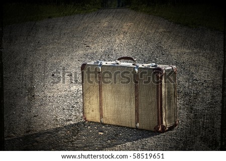 Old suitcase left on a dirt road