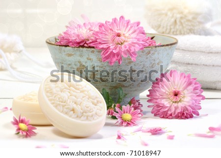 Spa scene with pink chrysanthemum flowers in water and soap