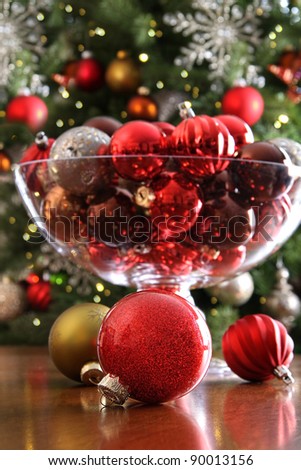 Christmas ornaments on table in front of holiday tree