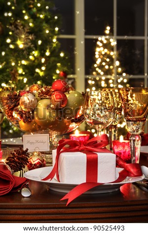 Festive dinner table setting with red ribbon gift
