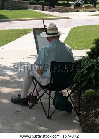 older man drawing on easel