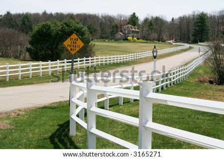 long road with fences and sign