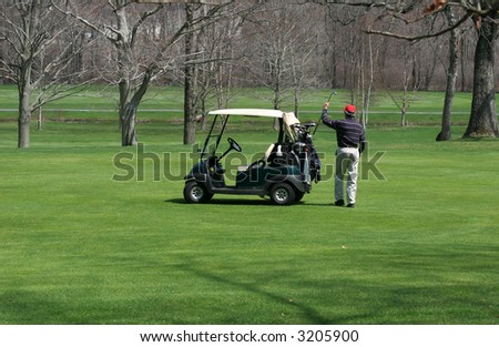 golfer putting golf-club in bag on golf-cart