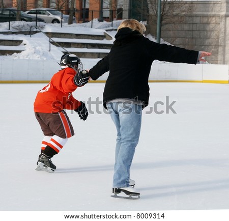 young hockey player helping mom ice skate