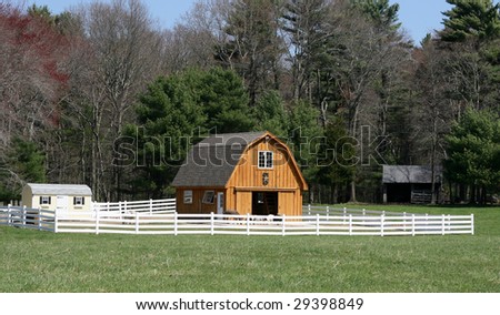 newly built barn with white fence