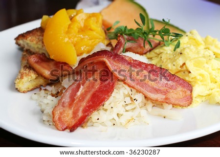 breakfast with eggs, bacon, hash browns, toast, peaches and canteloupe, shallow depth of field
