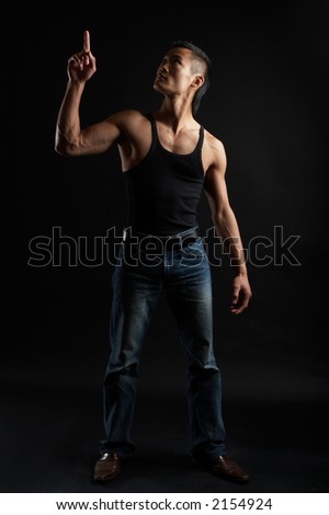 Great looking asian guy shot in studio - pointing upwards