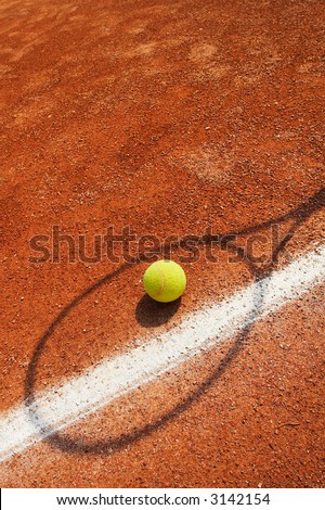 Tennis Concept - tennis ball near line with racket shadow over
