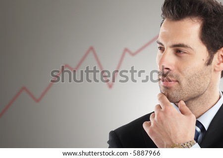Handsome Businessman looking at line graph in background