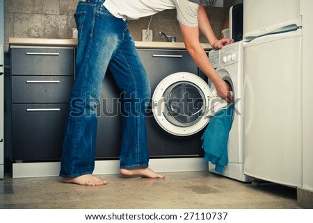 Concept Man putting his laundry into the washing machine