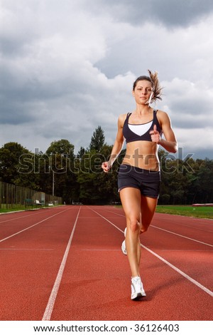 Athletic woman running on track Athletic woman running on track