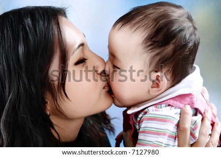 The mother kisses the baby