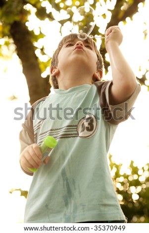 Five years old boy makes bubbles
