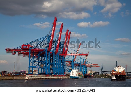 HAMBURG, GERMANY - JULY 13: A container ship is leaving the container port of Hamburg. It has to pass many cranes to find its way to the open sea on July 13, 2009 in Hamburg, Germany