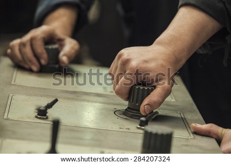 The hands of the two working switch levers and knobs on the old machine