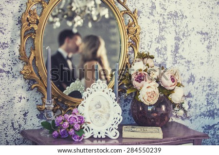 Vintage mirror with the bride and groom in the reflection on the wedding day