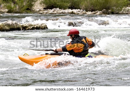 whitewater kayak paddler surfing a wave on grade 3 rapid