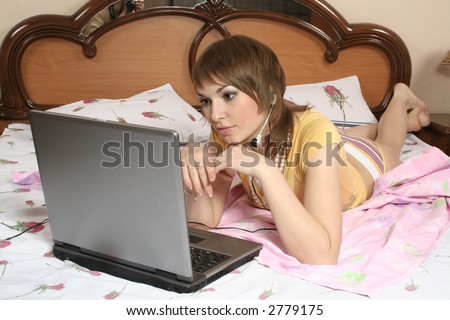 beautiful girl blonde on bed in underwear communicates by means of computer on  Internet morning