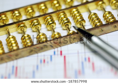 Business statistics chart and abacus, pen