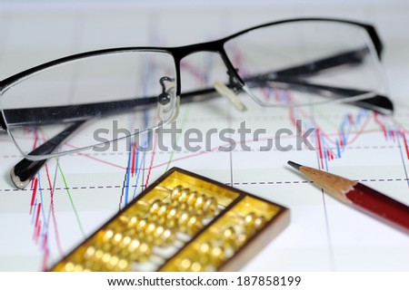 Business statistics charts, abacus and pen
