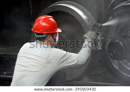 Anhui, Huaibei, China, May 18, 2015, a railway freight car repair work in spray paint.