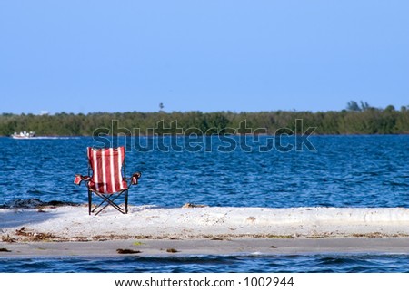 Pool chair abandoned on a deserted sandbar