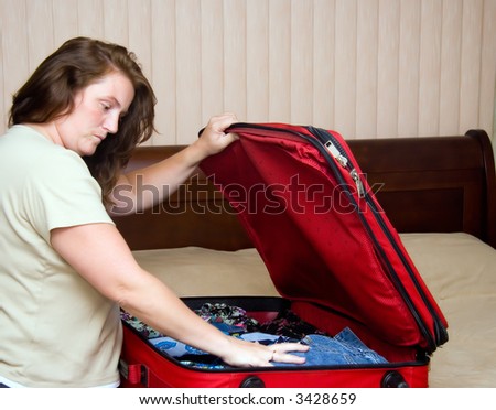 Lady packing suitcase for vacation or trip