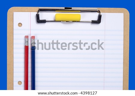 Clipboard with notebook paper, pencils and erasers arranged to provide copy space on paper.