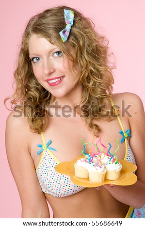 sexy model holding plate of cupcakes with twisted candles