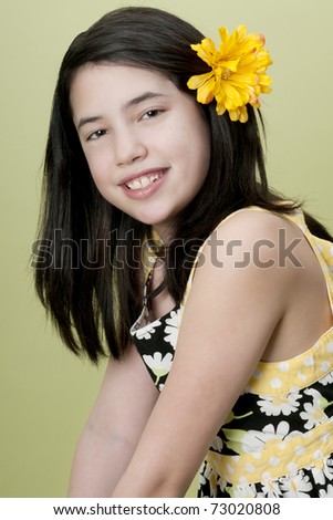 stock photo Preteen model posing with yellow flower in hair