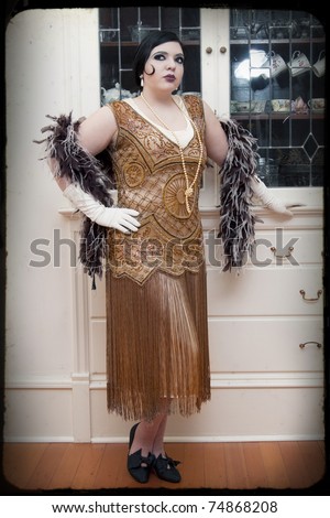 Beautiful art deco woman in retro styled clothes and feather boa