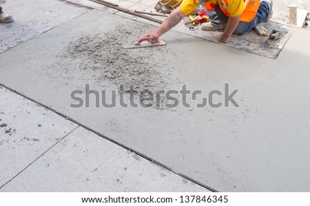 Spreading concrete for sidewalk repair