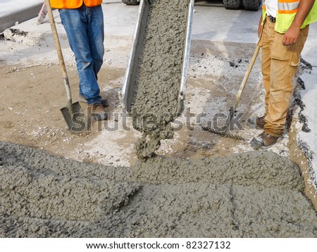 Pouring cement on newly paved road