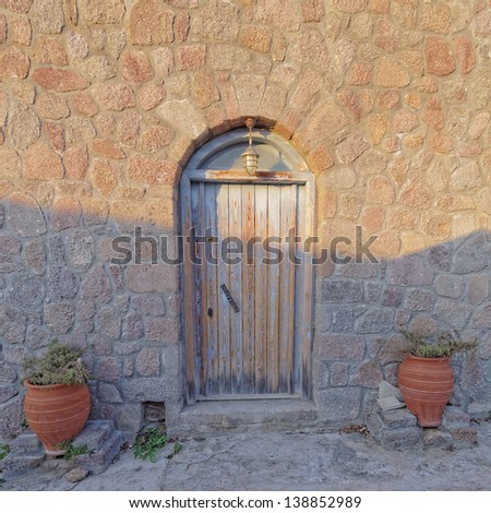 old house door and flowerpots between light and shadow