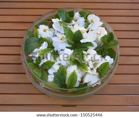 glass vase with gardenia flowers on wooden table